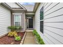 Inviting front entrance with a black front door, and well-kept landscaping with colorful plants at 1334 Sunnybrook Ln, Greenwood, IN 46143