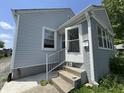 A view of the front porch stairs and door, painted white, of this home at 144 S 7Th Ave, Beech Grove, IN 46107