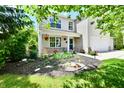 Charming home featuring manicured landscaping, flower beds, and a welcoming covered porch at 16857 Palmetto Way, Noblesville, IN 46062