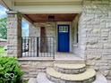 Covered front porch with a striking blue door and stone pillars at 1920 E Epler E Ave, Indianapolis, IN 46227