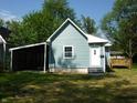 Charming home exterior with blue siding, white trim, carport, and well-maintained lawn at 2007 Park Ave, Anderson, IN 46016