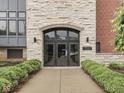 Exterior building entrance with stone facade and well-maintained landscaping at 222 N East St # 103, Indianapolis, IN 46204