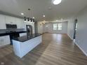 Open-concept kitchen featuring white cabinets, black countertops, stainless appliances and an island at 223 N Coventry Dr, Anderson, IN 46012