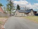 Rear exterior of stone home showing long driveway leading to gate at 3659 Watson Rd, Indianapolis, IN 46205