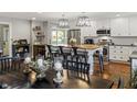 Bright kitchen with island seating, stainless appliances, and hardwood floors adjacent to dining area at 3904 Haverhill Dr, Indianapolis, IN 46240