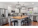 Modern kitchen with white cabinets, butcher block island, stainless steel appliances, and pendant lighting at 3904 Haverhill Dr, Indianapolis, IN 46240