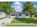Well-maintained single-story house featuring a charming front yard and a gravel driveway at 410 W Douglas St, Martinsville, IN 46151