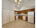 Functional kitchen with ample cabinet space, white appliances, and neutral tile flooring at 413 Woodberry Dr, Danville, IN 46122