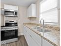 Well-lit kitchen featuring granite countertops, stainless steel oven and modern faucet at 429 Colescott St, Shelbyville, IN 46176