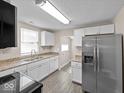 Bright kitchen featuring white cabinets, stainless steel refrigerator, and modern appliances at 429 Colescott St, Shelbyville, IN 46176