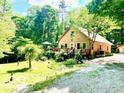 Charming tan home exterior with a large front yard, deck, and mature trees for shade at 4419 Liberty Loop Rd, Martinsville, IN 46151