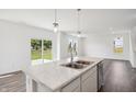Bright kitchen island featuring a double sink, stainless steel dishwasher, and pendant lighting at 4785 E Shadowbrook Dr, Camby, IN 46113