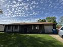 Single story brick home with attached garage featuring a well maintained lawn at 5601 Milhouse Rd, Indianapolis, IN 46221