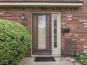 Inviting front entrance with brick surround, accent plants, and seating at 57 Trails End St, Greenwood, IN 46142