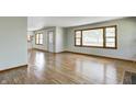 Bright living room with gleaming hardwood floors and ample natural light, seamlessly flowing into the adjacent spaces at 5941 North St, Stilesville, IN 46180