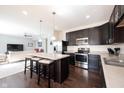 Open-concept kitchen with a breakfast bar, stainless steel appliances, and hardwood floors at 635 Sonoma Ln, Greenfield, IN 46140