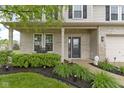 Inviting front porch with brickwork, decorative shrubbery, and a charming entrance at 6822 Woodford Ln, Indianapolis, IN 46237