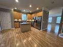 Bright kitchen with wood floors, an island, stainless steel appliances, and tan cabinetry at 6924 Havenmoor Pl, Indianapolis, IN 46250