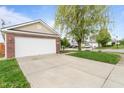 Spacious two car garage with large driveway and mature trees in a well-maintained yard at 805 Sunvista Dr, Avon, IN 46123