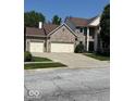 Charming two-story brick home featuring a two-car garage and well-manicured lawn at 8130 Winterset Cir, Indianapolis, IN 46214