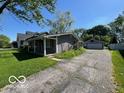 Side view of ranch style home with green lawn and detached garage at 825 W Auman Dr, Carmel, IN 46032