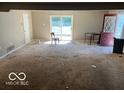 Empty living room with sliding doors, a red door and worn carpet at 825 W Auman Dr, Carmel, IN 46032