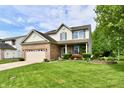 Inviting two-story home with lush green lawn, brick facade, and vibrant landscaping at 938 Weeping Way Ln, Avon, IN 46123