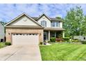 Charming two-story home with brick and siding, a well-manicured lawn and lovely flower beds at 938 Weeping Way Ln, Avon, IN 46123