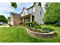 Beautifully landscaped front yard with colorful flowerbeds and well-manicured lawn enhances curb appeal at 938 Weeping Way Ln, Avon, IN 46123