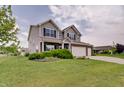 Beautiful home with lush green lawn, mature trees and shrubs, and a two-car attached garage at 951 Gondola Run, Greenfield, IN 46140