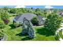 Aerial view of a brick and yellow siding home with an expansive lawn and established trees at 1020 Lair Ct, Westfield, IN 46074