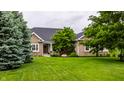 Beautiful brick and yellow siding home with a large, well-manicured green lawn and mature trees at 1020 Lair Ct, Westfield, IN 46074