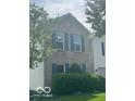 Charming two-story home with light brick, dark shutters and well-manicured landscaping at 10746 Raven Ct, Fishers, IN 46038