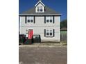Charming two-story home featuring a striking red door, gray siding, and classic black shutters at 1128 S Pennsylvania St, Indianapolis, IN 46225
