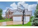 Lovely brick home featuring a three-car garage, a basketball hoop, and a well-manicured front lawn at 13145 Roma Bnd, Carmel, IN 46074