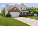 Inviting two-story home with brick and siding, a well-maintained lawn, and an attached garage at 14135 Nicholas Dr, Carmel, IN 46074