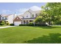 Beautiful home featuring a well-manicured lawn, mature trees, and brick and siding exterior at 14135 Nicholas Dr, Carmel, IN 46074