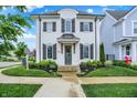 Charming two-story home featuring a white brick facade, black shutters, and a beautifully landscaped front yard at 15116 Fenchurch Dr, Westfield, IN 46074