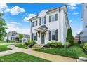 An exterior elevation showing a white brick home, beautiful yard, and a lovely curved sidewalk at 15116 Fenchurch Dr, Westfield, IN 46074