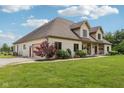 Side view of a house with a gravel driveway, lawn, and garage at 2825 S State Road 267, Plainfield, IN 46168