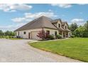 Side view of a house with a gravel driveway, lawn, and garage at 2825 S State Road 267, Plainfield, IN 46168