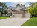 Side view of a brick home with a spacious driveway and three car garage at 3251 Amber Way, Bargersville, IN 46106