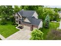 Attractive two-story home showcasing a manicured lawn, lush landscaping, and a convenient three-car garage at 3251 Amber Way, Bargersville, IN 46106