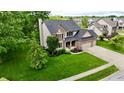 Beautiful two-story home with a well-manicured lawn, lush landscaping and charming brick and vinyl facade at 3251 Amber Way, Bargersville, IN 46106