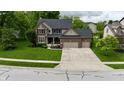 Stunning two-story home featuring a well-manicured lawn and a spacious three-car garage and brick exterior at 3251 Amber Way, Bargersville, IN 46106
