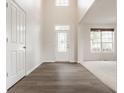 Inviting foyer featuring wood-look flooring, a stylish front door, and soaring ceilings at 3419 Burlingame Blvd, Carmel, IN 46074