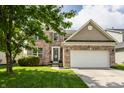 Charming two-story brick home with a well-manicured lawn and attached two-car garage at 3419 Burlingame Blvd, Carmel, IN 46074