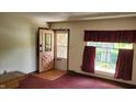 Bright living room with large window, carpet, and a glass-paneled front door at 3702 Candy Cane Dr, Indianapolis, IN 46227