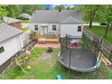 Spacious backyard featuring a wooden deck, patio, playset, and trampoline; perfect for outdoor fun at 376 S Arlington Ave, Indianapolis, IN 46219