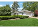 Lovely single-story home featuring lush green lawn and manicured landscaping at 410 Sugar Tree Ln, Indianapolis, IN 46260